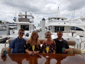 Two beautiful couples drinking mimosa and beer on the yacht