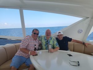 Three people laughing on a yacht