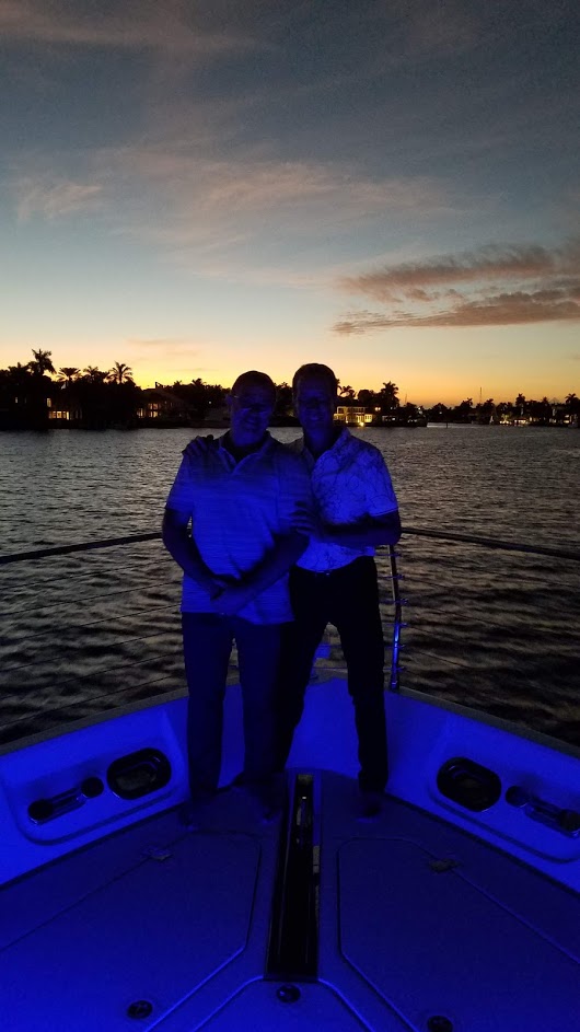Two person standing on a yacht with blue lights