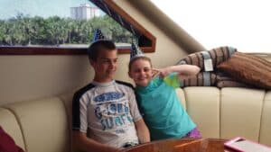 Two kids with birthday caps on the yacht